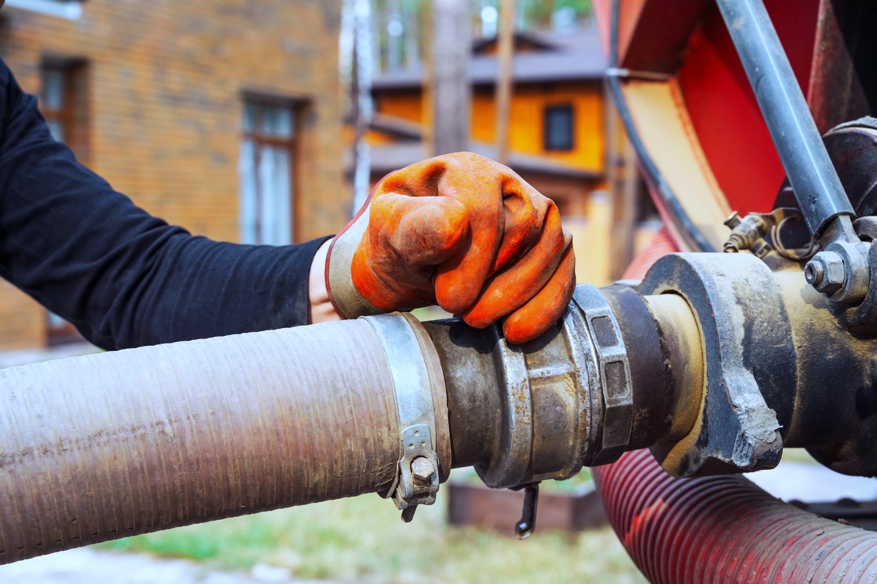 A gloved hand tightening a hose coupling